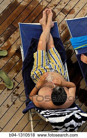 Cruise ship. Man swinsuit with a drink. View Large Photo Image Stock Photo - Cruise ship. Man swinsuit with a drink.. Fotosearch