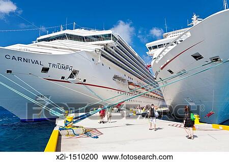 Stock Image - Cruise ship passengers on pier disembarking from Carnival cruise ships Triumph and Ecstasy in Cozumel, Mexico in the Caribbean Sea. Fotosearch