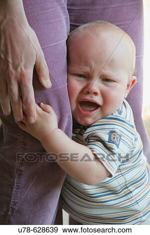 Crying baby clinging to mother's legs View Large Photo Image Stock Photo - Crying baby clinging to mother's legs. Fotosearch