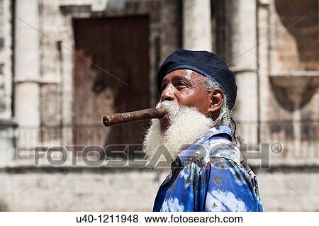 Stock Photo - Cuba, Havana Vieja, Plaza de la Catedral, man with cigar. Fotosearch