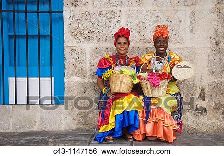 Cuba - Some women in Habana Vieja, the Old Town of Cuba's capital Havana, wear beautifully coloured dresses and for some money pose for photographs View Large Photo Image Stock Photograph - Cuba - Some women in Habana Vieja, the Old Town of Cuba's capital Havana, wear beautifully coloured dresses and for some money pose for photographs. Fotosearch