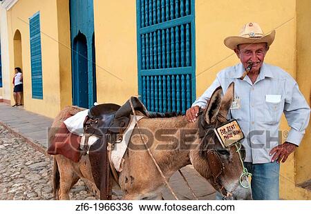 Cuba Trinidad old man with cowboy hat with donkey for rides in center of old colonial city. View Large Photo Image Stock Photograph - Cuba Trinidad old man with cowboy hat with donkey for rides in center of old colonial city.. Fotosearch