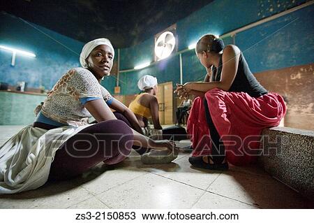 Stock Image - Cuban dancers resting during a break at the rehearsal in an old hall, Santiago de Cuba, Cuba, West Indies, Central America.. Fotosearch