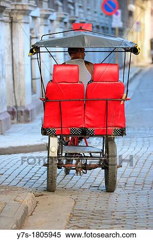 Stock Photography - Cuban Taxi driver waiting for customers in bicycle-taxi in Havana, Cuba. Fotosearch