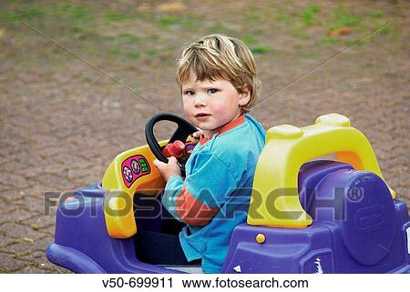 Cude blond, blue eyed boy in his colourful toy car in a farm in Cambridge, Hautapu, New Zealand View Large Photo Image Stock Image - Cude blond, blue eyed boy in his colourful toy car in a farm in Cambridge, Hautapu, New Zealand. Fotosearch