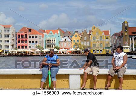 Cura? ao, Netherlands Antilles, Dutch, Willemstad, Otrobanda, Punda, Handelskade, waterfront, St Sint Anne Bay, Koningin Emmabrug, UNESCO World Heritage Site, colonial architecture, preservation, restoration, pastel color, Black, woman, man, sitting, View Large Photo Image Stock Photo - Cura? ao, Netherlands Antilles, Dutch, Willemstad, Otrobanda, Punda, Handelskade, waterfront, St Sint Anne Bay, Koningin Emmabrug, UNESCO World Heritage Site, colonial architecture, preservation, restoration, pastel color, Black, woman, man, sitting,. Fotosearch