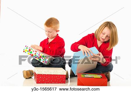 Curious children impatiently opening Christmas presents View Large Photo Image Stock Photo - Curious children impatiently opening Christmas presents. Fotosearch