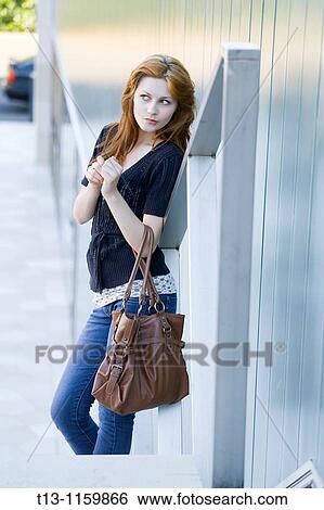 Curious with a purse in hand young woman View Large Photo Image Stock Photograph - Curious with a purse in hand young woman. Fotosearch