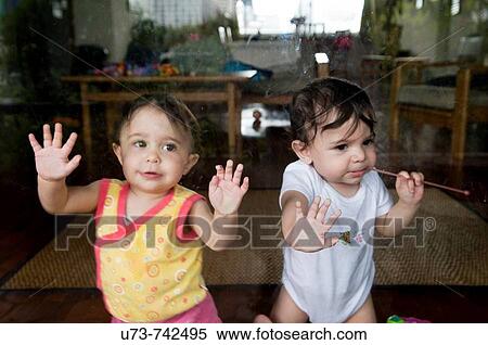 Cute 1 year old twins play by the window View Large Photo Image Stock Photography - Cute 1 year old twins play by the window. Fotosearch