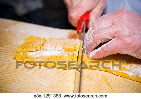 Stock Photo - Cutting handmade fettuccine, close-up. Fotosearch