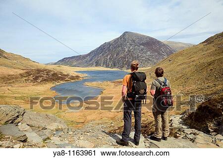 Stock Image - Cwm Idwal, Gwynedd, North Wales, UK, Europe Walkers by Llyn Idwal in the mountains of Snowdonia National Park. Fotosearch