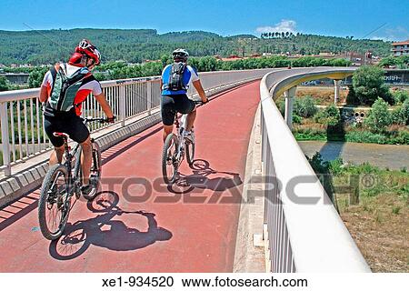 Stock Image - Cyclists in the viaduct on the Llobregat river, Castellbisbal, Catalonia, Spain.. Fotosearch