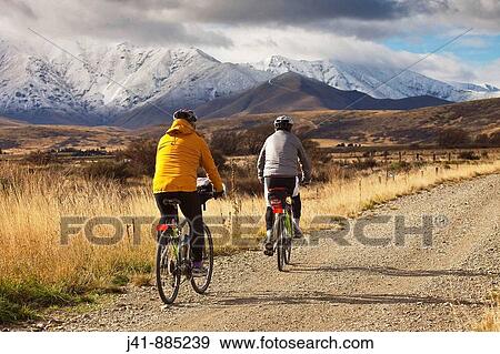 Stock Photo - Cyclists on Otago Rail Trail near Oturehua, Central Otago, New Zealand. Fotosearch