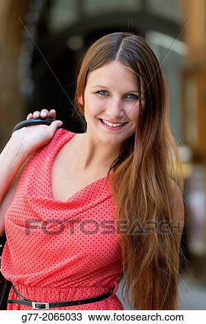 Stock Image - Czech Republic. Prague. Young smiling woman walking on a street in Old Prague.. Fotosearch