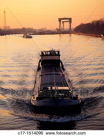 Stock Photograph - D-Huenxe, Lippe, Wesel-Datteln Canal, nature reserve Hohe Mark, Lower Rhine, Ruhr area, Rhineland, North Rhine-Westphalia, NRW, cargo ship on the Wesel-Datteln Canal before the lock, canal lock, evening mood, sunset, afterglow. Fotosearch
