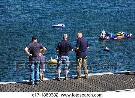 Stock Image - D-Krefeld, Rhine, Lower Rhine, Rhineland, North Rhine-Westphalia, NRW, D-Krefeld-Uerdingen, Elfrather See, Elfrath Lake, people at the lakeshore, model ships, telecontrol, hobby. Fotosearch
