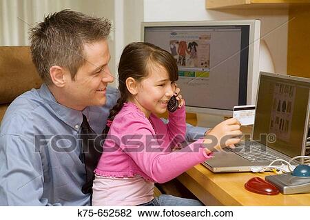 Stock Image - Dad and daughter shopping online. Fotosearch