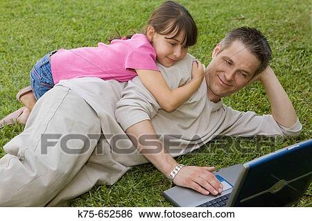 Dad and daughter using laptop outdoors View Large Photo Image Stock Photograph - Dad and daughter using laptop outdoors. Fotosearch