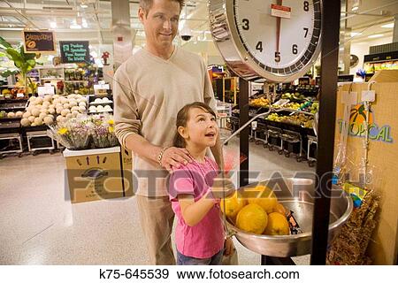 dad and daughter weighing fruit in supermarket View Large Photo Image Stock Photo - dad and daughter weighing fruit in supermarket. Fotosearch