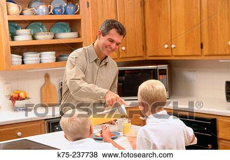 Stock Photo - Dad and his sons at breakfast. Fotosearch