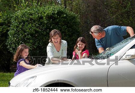Dad and mom and daughters family washing car at home in driveway together with hose and having fun View Large Photo Image Picture - Dad and mom and daughters family washing car at home in driveway together with hose and having fun. Fotosearch