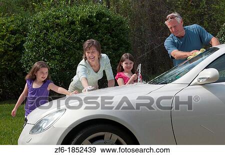 Dad and mom and daughters family washing car at home in driveway together with hose and having fun View Large Photo Image Stock Photo - Dad and mom and daughters family washing car at home in driveway together with hose and having fun. Fotosearch