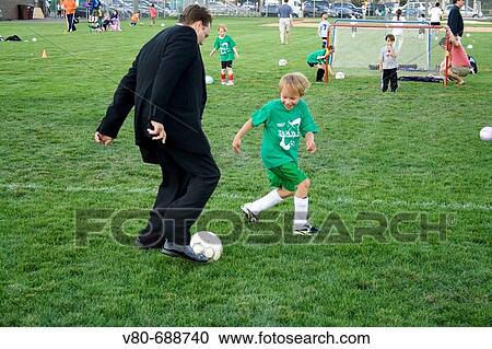 Dad in business suit playing soccer with son after game age 37 and 7 Carondelet Field by Expo School St Paul Minnesota USA View Large Photo Image Stock Image - Dad in business suit playing soccer with son after game age 37 and 7 Carondelet Field by Expo School St Paul Minnesota USA. Fotosearch