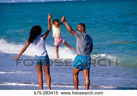 Dad, mom, and daughter at the beach View Large Photo Image Stock Photography - Dad, mom, and daughter at the beach. Fotosearch