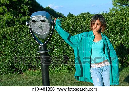 Dark skin teen girl, at a park, leaning against a viewing device View Large Photo Image Stock Photograph - Dark skin teen girl, at a park, leaning against a viewing device. Fotosearch