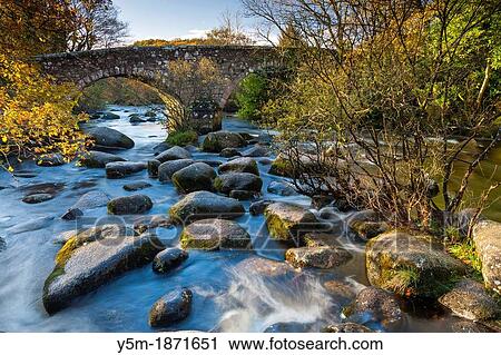Dartmeet Bridge over the East Dart River flowing through woodland in Dartmoor National Park, Devon, England, UK, Europe View Large Photo Image Stock Image - Dartmeet Bridge over the East Dart River flowing through woodland in Dartmoor National Park, Devon, England, UK, Europe. Fotosearch