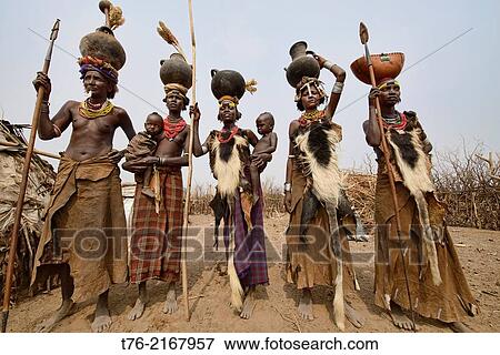Dassanech women with hyena pelt skins and jugs on their heads in the Lower Omo Valley of Ethiopia. View Large Photo Image Stock Photo - Dassanech women with hyena pelt skins and jugs on their heads in the Lower Omo Valley of Ethiopia.. Fotosearch