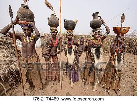 Dassanech women with hyena pelt skins and jugs on their heads in the Lower Omo Valley of Ethiopia. View Large Photo Image Stock Photo - Dassanech women with hyena pelt skins and jugs on their heads in the Lower Omo Valley of Ethiopia.. Fotosearch