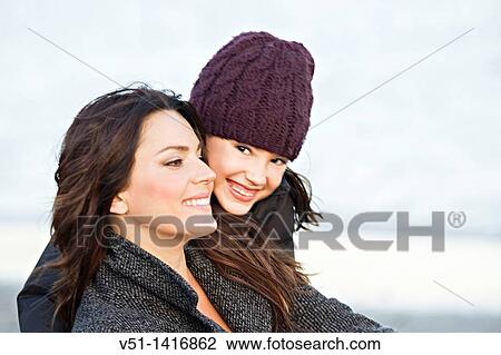 Stock Image - Daughter giving a hug to her mother at the beach. Fotosearch