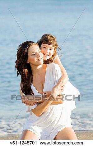 Daughter giving a hug to her mother in the seashore at the beach View Large Photo Image Stock Image - Daughter giving a hug to her mother in the seashore at the beach. Fotosearch