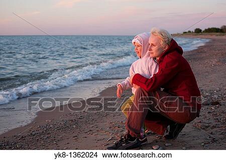 Picture - Daughter with Mother at Sunset on Beach by Sea. Fotosearch