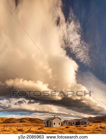 Dawn lights up cloudscape over historic (1939) farm buildings near St Bathans, Central Otago, New Zealand. View Large Photo Image Stock Image - Dawn lights up cloudscape over historic (1939) farm buildings near St Bathans, Central Otago, New Zealand.. Fotosearch