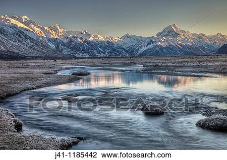 Dawn lights up eastern faces of Aoraki/ mt Cook from frosted grass Tasman River flats, Aoraki / Mt cook National Park, New Zealand. View Large Photo Image Stock Image - Dawn lights up eastern faces of Aoraki/ mt Cook from frosted grass Tasman River flats, Aoraki / Mt cook National Park, New Zealand.. Fotosearch