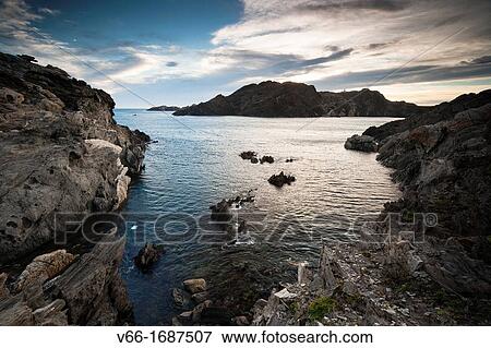 Stock Photo - Dawn on the Cap de Creus with the lighthouse in the background mound. Fotosearch