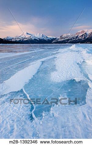 Stock Photograph - Daybreak over the wind blasted surface of Abraham Lake, Alberta Canada. Fotosearch