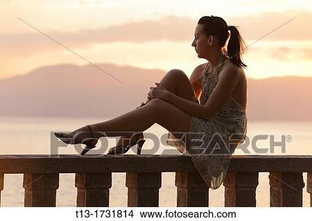 Daydreaming on a fence young woman View Large Photo Image Picture - Daydreaming on a fence young woman. Fotosearch