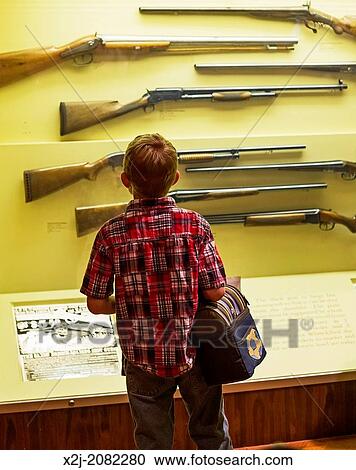 Dearborn, Michigan - A boy studies a display of shotguns at the Henry Ford Museum. View Large Photo Image Stock Image - Dearborn, Michigan - A boy studies a display of shotguns at the Henry Ford Museum.. Fotosearch