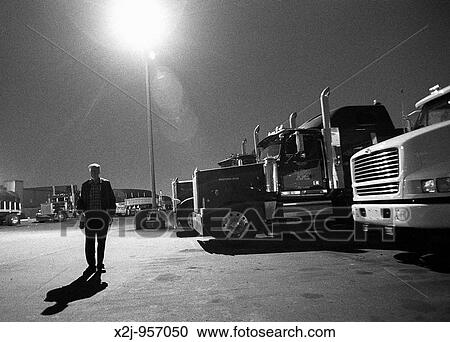 Stock Image - Dearborn, Michigan - Teamster truck driver at a truck stop in a busy, industrial area near Detroit MR. Fotosearch