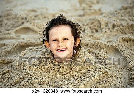 Delighted young girl buried in the beach sand, Cape Cod, MA View Large Photo Image Stock Photo - Delighted young girl buried in the beach sand, Cape Cod, MA. Fotosearch