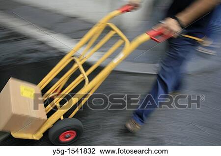delivery man walking in street road in city town View Large Photo Image Stock Image - delivery man walking in street road in city town. Fotosearch