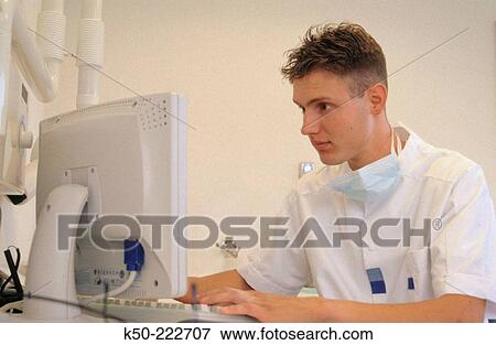 Dentist analysing data at his computer. Netherlands View Large Photo Image Stock Photo - Dentist analysing data at his computer. Netherlands. Fotosearch
