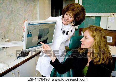 Dentist helping a patient understand a dental treatment using the computer St Paul Minnesota MN USA View Large Photo Image Stock Photograph - Dentist helping a patient understand a dental treatment using the computer St Paul Minnesota MN USA. Fotosearch