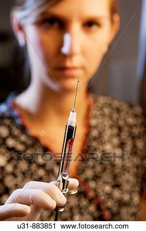 Stock Image - Dentist showing anesthesia injection. Fotosearch
