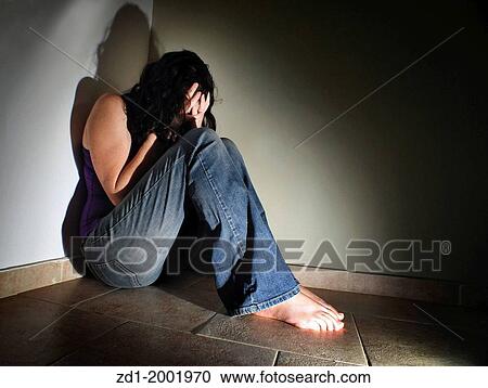 Depressed young woman sitting on the floor at home suffering from a severe depression. View Large Photo Image Stock Image - Depressed young woman sitting on the floor at home suffering from a severe depression.. Fotosearch