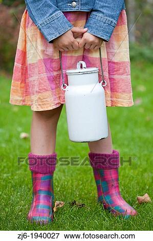 Detail of a girl girl holding a milk can in the garden. Slovenian countryside. View Large Photo Image Stock Photo - Detail of a girl girl holding a milk can in the garden. Slovenian countryside.. Fotosearch