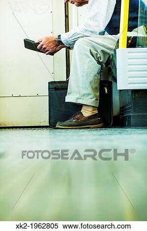 Detail of a man reading in the tube, London, UK View Large Photo Image Stock Photography - Detail of a man reading in the tube, London, UK. Fotosearch